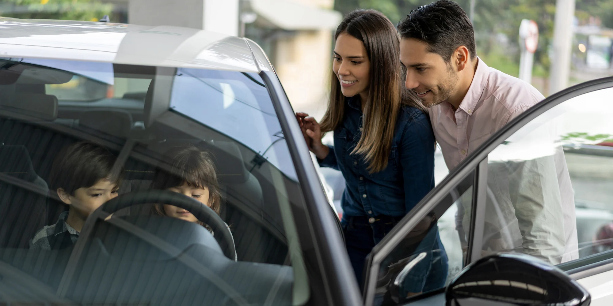 Family speaking with car dealer